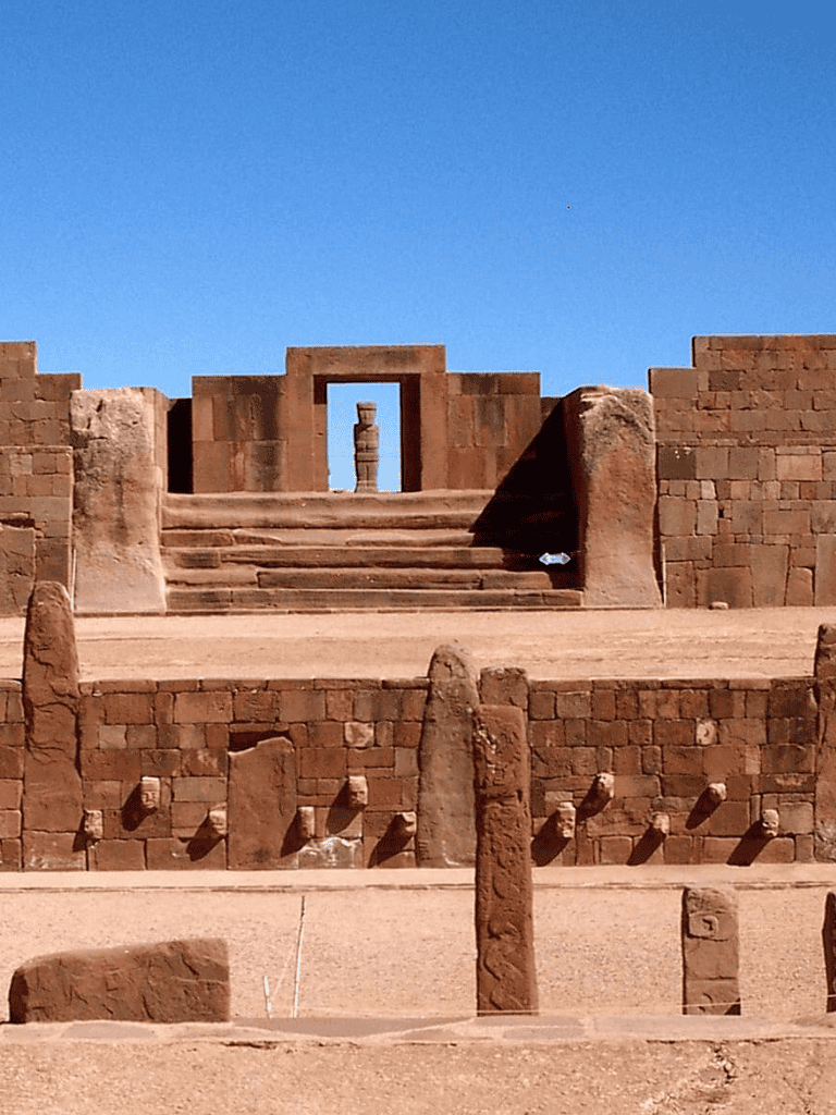 Ancient desert ruins with stone staircases and historical stone columns, showcasing archaeological excavation site.