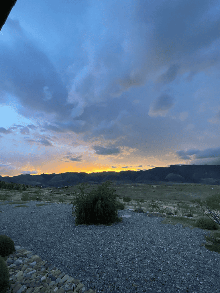 Serene desert landscape with mountain backdrop during sunset, showcasing scenic wilderness and natural beauty.