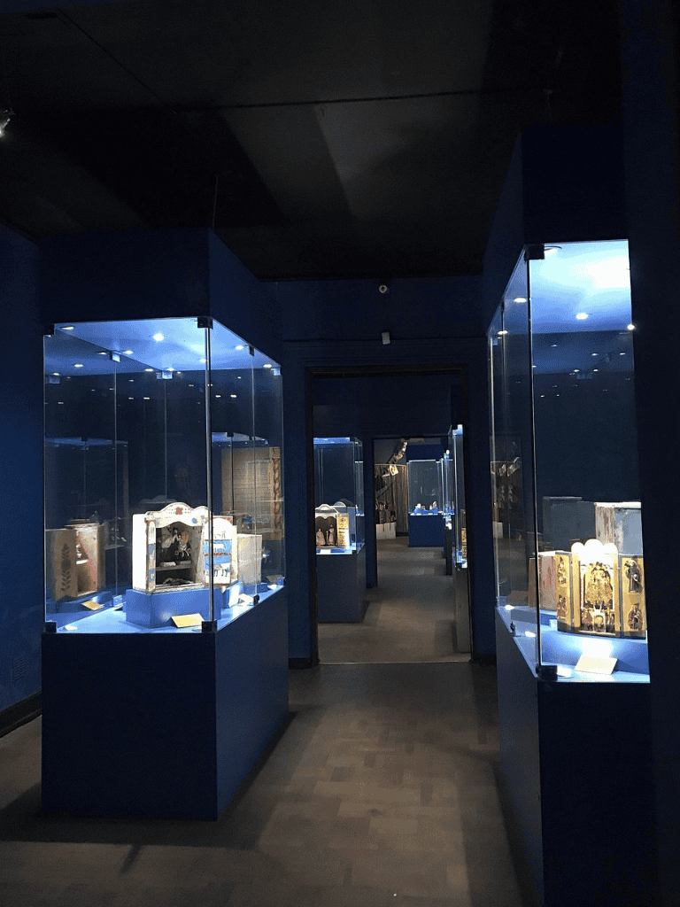 Ancient artifact exhibit with glass display cases and dark blue walls at QuestForDirections museum.