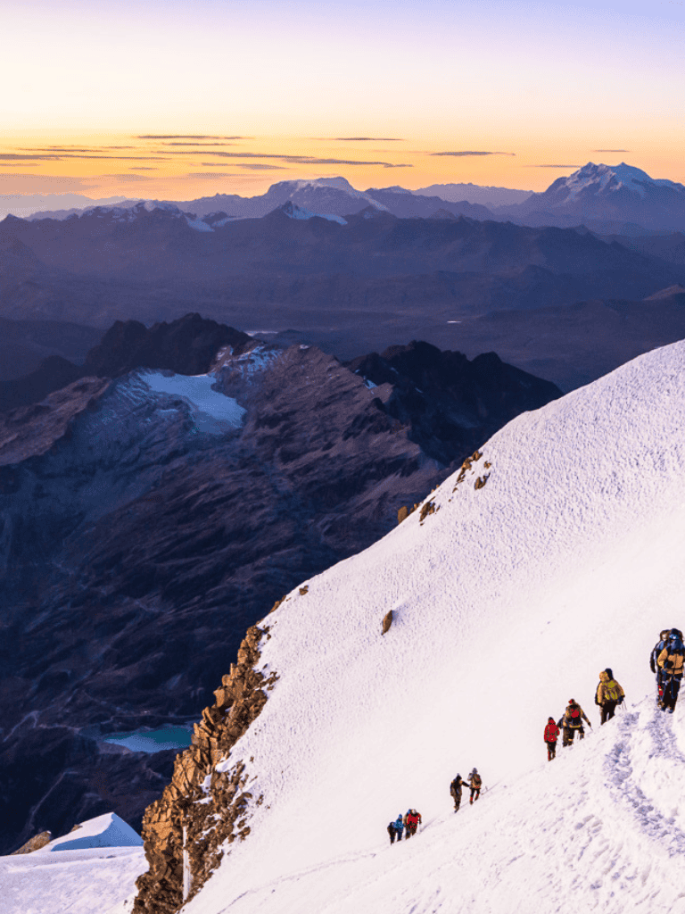 Snow-capped mountain climbing adventure with hikers and stunning mountain views at sunrise or sunset.