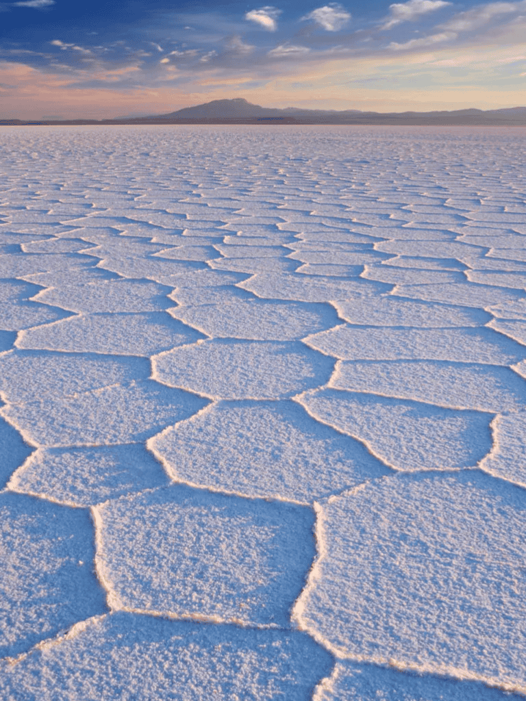 Salt flats landscape with geometric salt pan patterns at sunset, Utah.