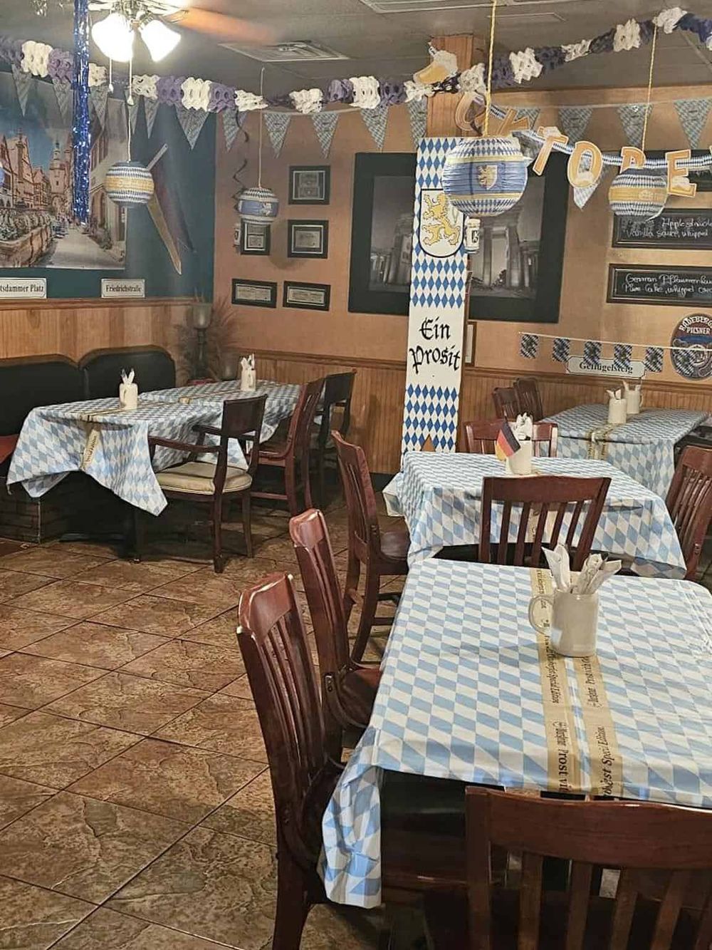 Cozy Bavarian-themed restaurant with traditional decorations and blue-and-white checkered tablecloths.
