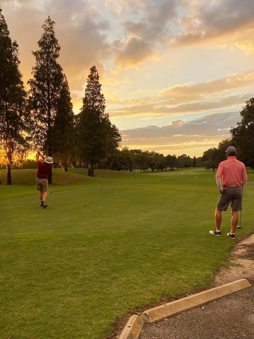 Well-maintained golf course during sunset with two golfers, perfect for golf course landscape SEO.