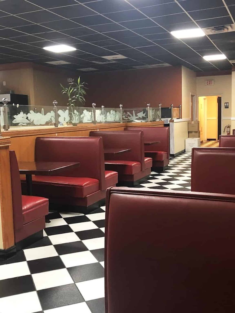 Quiet diner booth seating with black and white checkered flooring, perfect for restaurant dining and takeout.