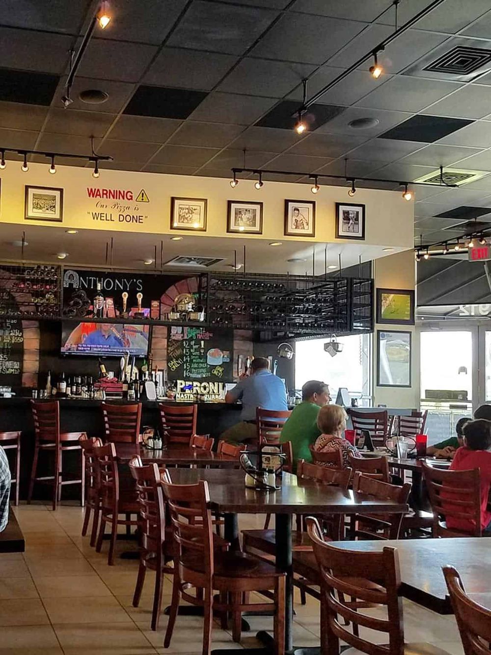 Bright, cozy restaurant interior with bar and customers, inviting atmosphere for dining and hospitality.