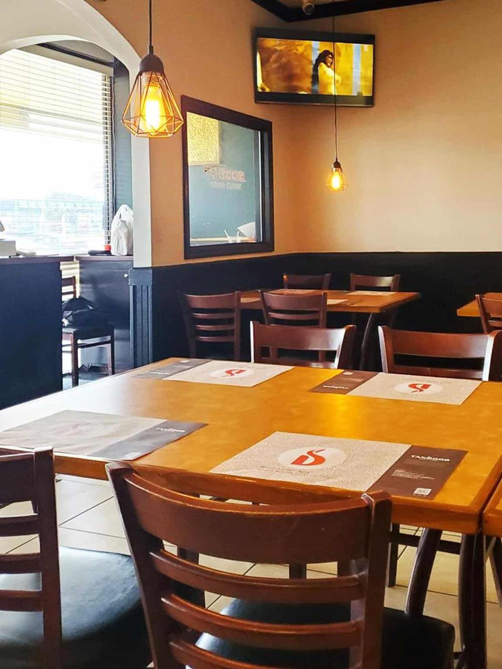 Cozy restaurant interior with wooden tables, chairs, and warm lighting, ideal for casual dining experiences.