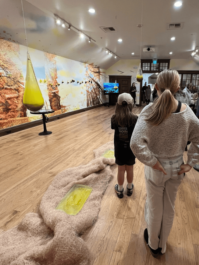 Colorful art installation with hanging glass sculptures at QuestForDirections exhibit.