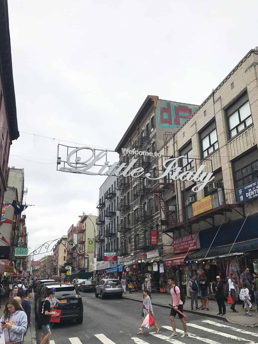 Vibrant Chinatown street scene in NYC with shops, pedestrians, and iconic street signs.