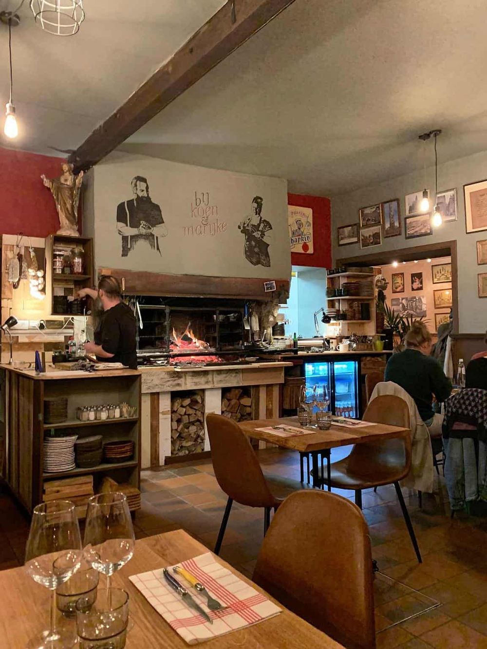 Cozy restaurant interior with rustic decor, wood accents, and a fireplace, offering a warm atmosphere for dining and comfort.