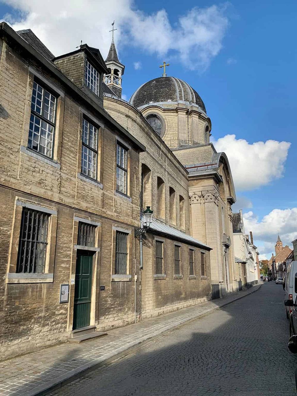Ancient stone church with historic architecture in a sunny European street, part of QuestForDirections.