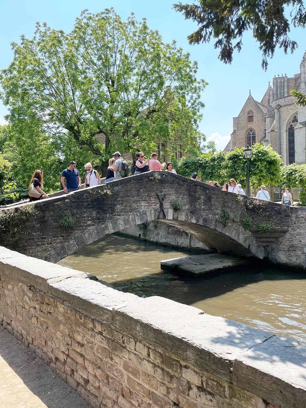 Charming stone bridge in historic European city, popular for sightseeing and walking tours.
