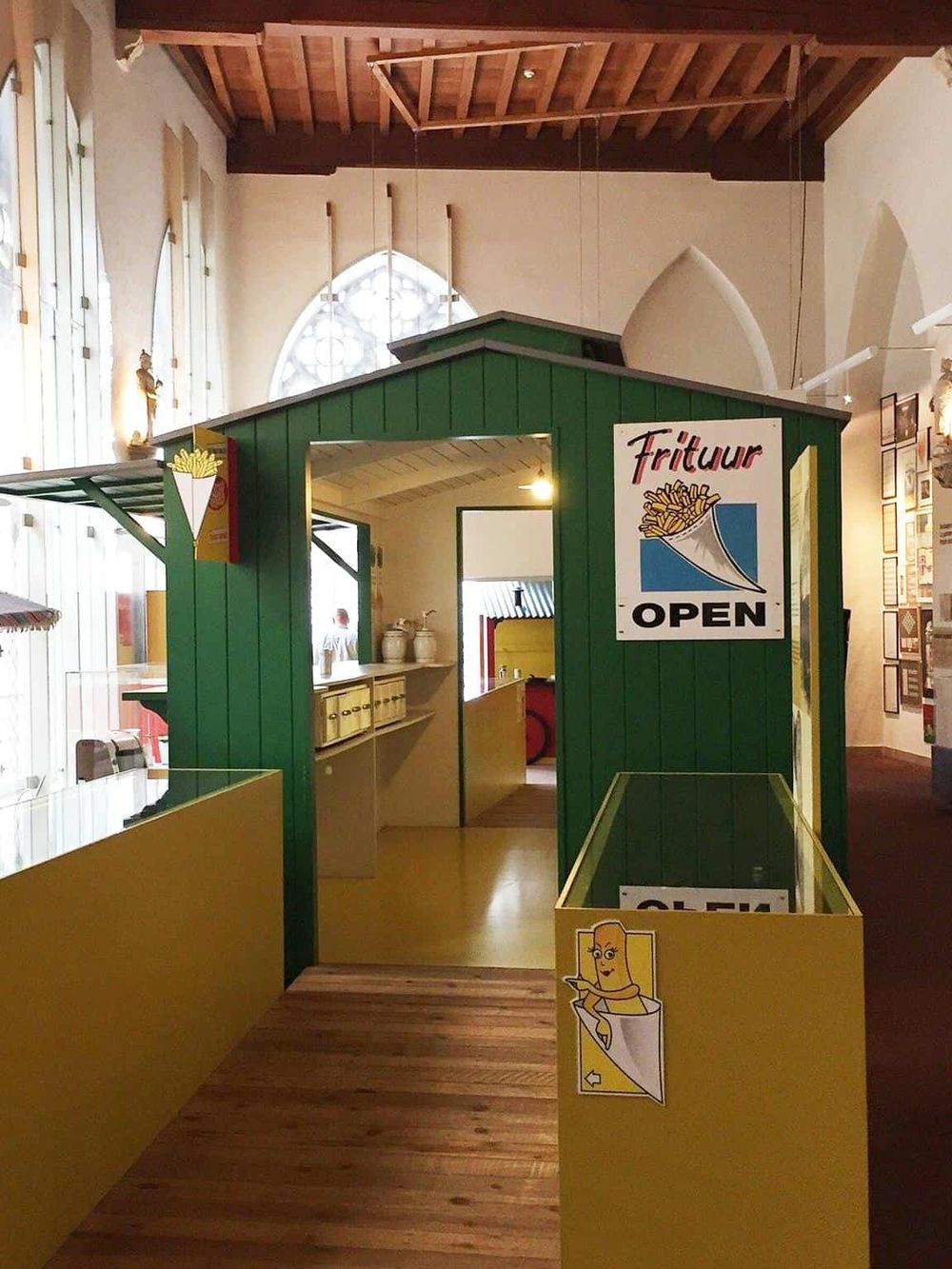 Colorful fast food kiosk inside a historic building with high ceilings and large windows.