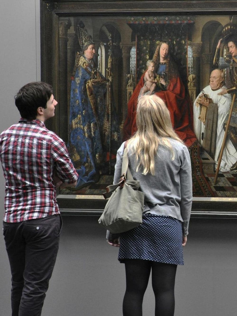 Intriguing visitors exploring classical religious art at QuestForDirections museum exhibit.