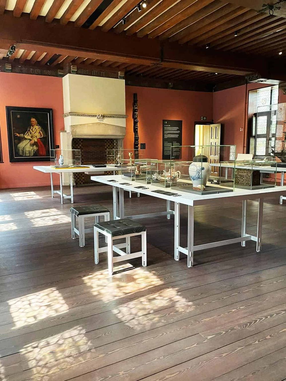 Vase and artifact display at QuestForDirections museum exhibit in a historic building, showcasing cultural heritage.