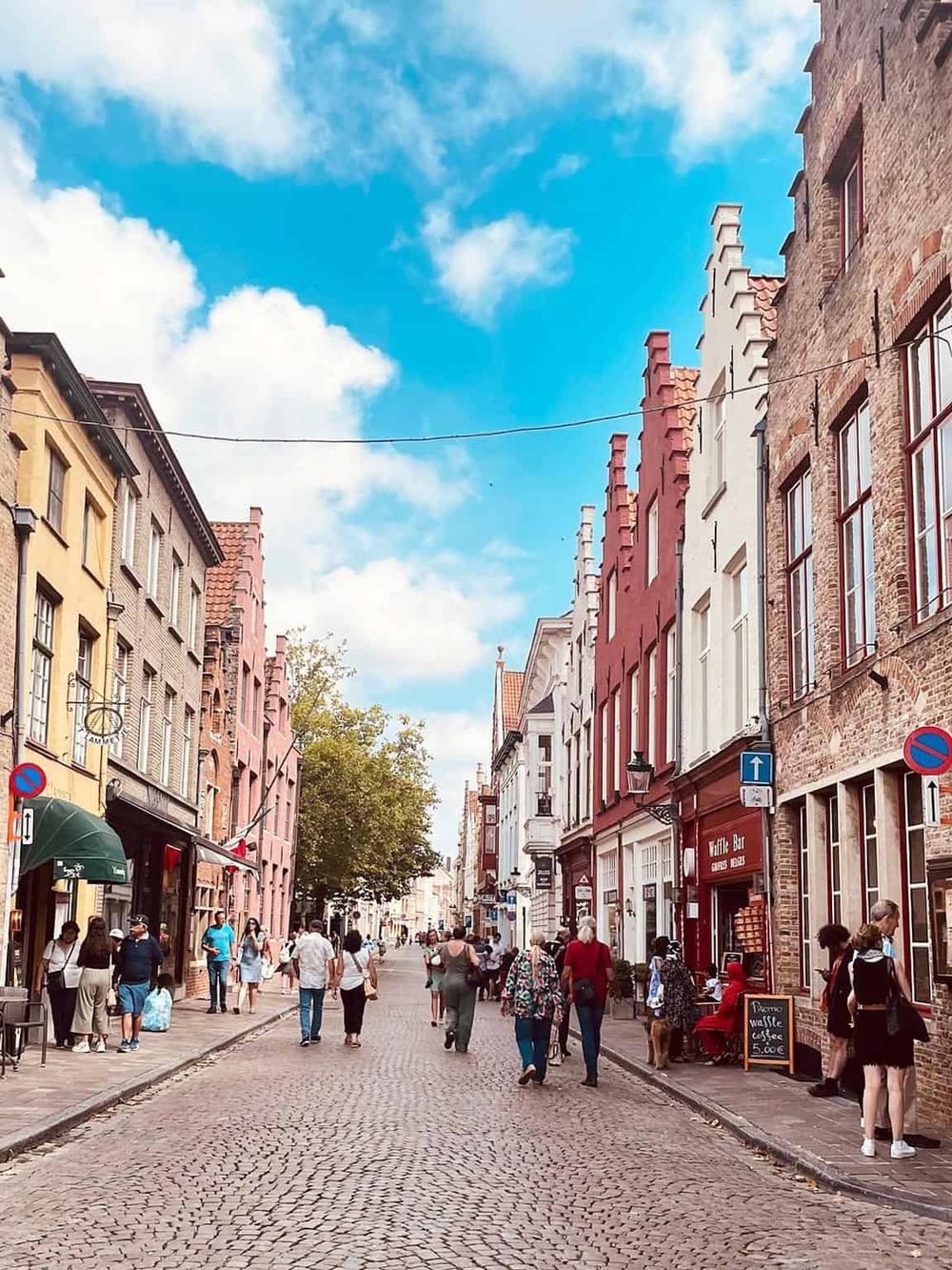 Vibrant European street scene with colorful historic buildings, pedestrians, and cafes, highlighting local culture and architecture.