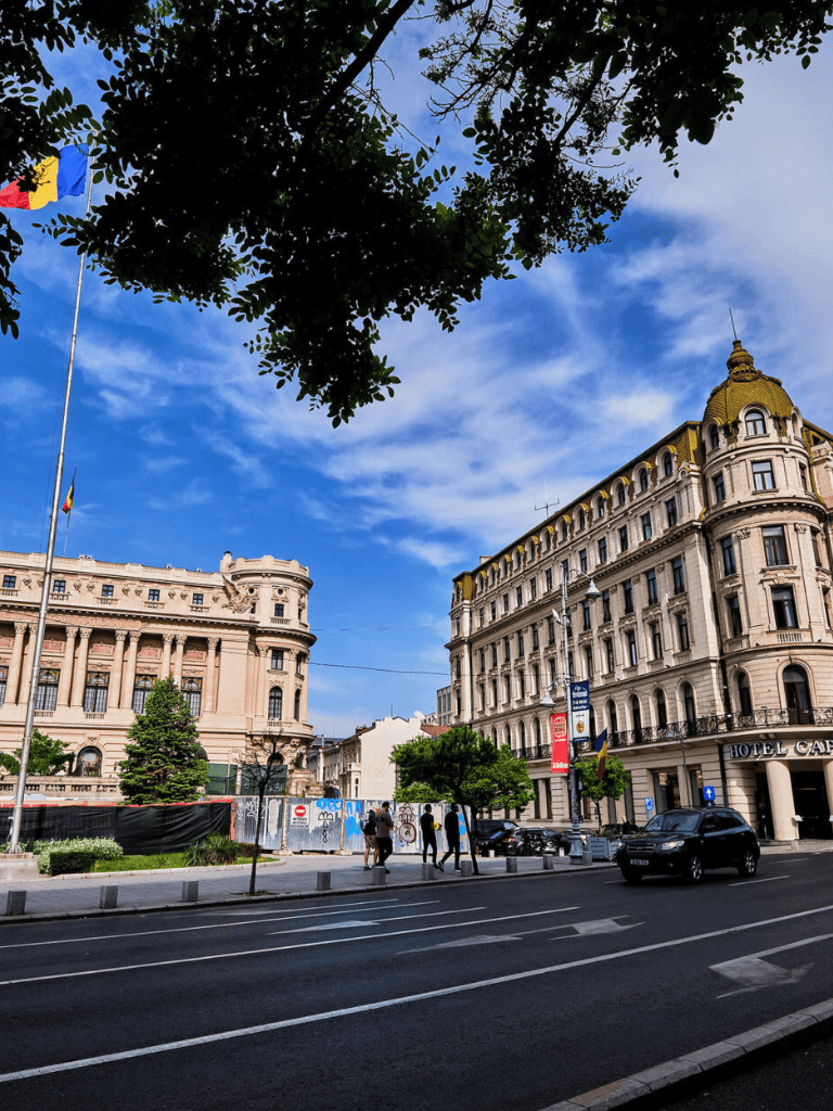 Aerial view of historic European city street with grand architecture and people walking.