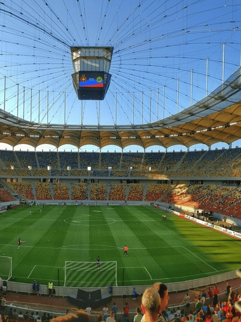 Blank stadium with a large digital scoreboard and a Ferris wheel in the background, ready for a sports event.
