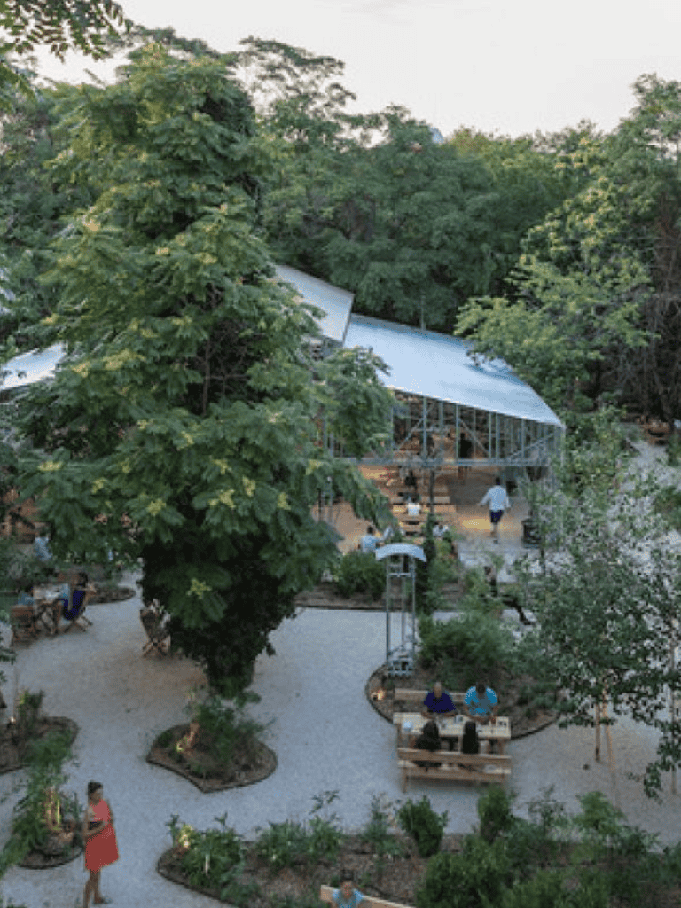 Lush outdoor dining area nestled among trees at Quest for Directions.