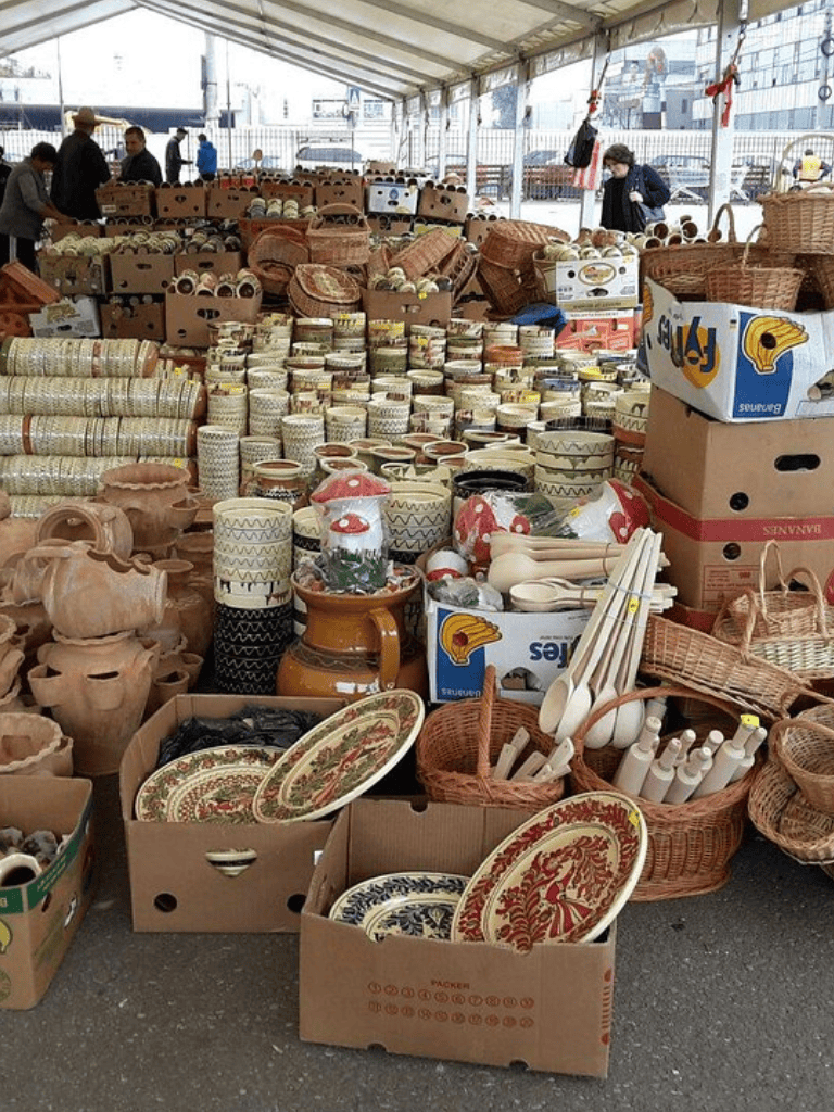 Colorful ceramic tableware and pottery at an outdoor market.