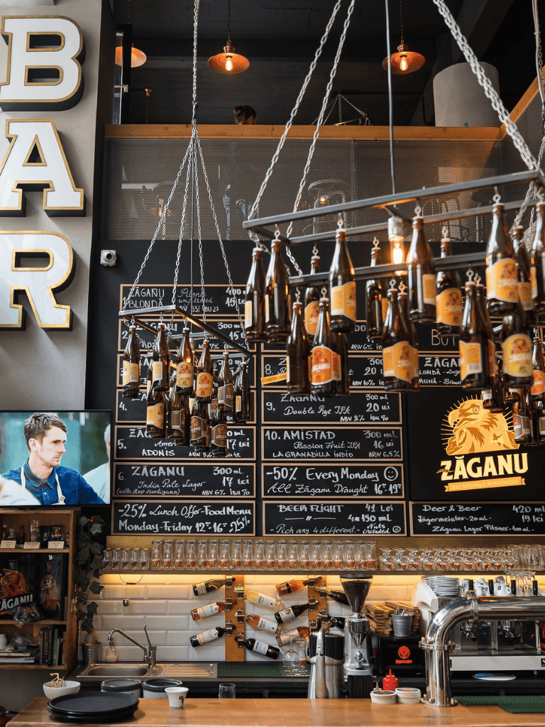 Charming bar with hanging beer bottles, blackboard menus, and cozy interior decor perfect for beer lovers.