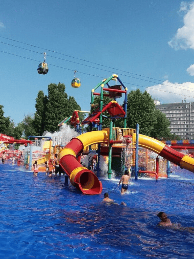 Colorful water park with slides and a splash zone under a clear blue sky.