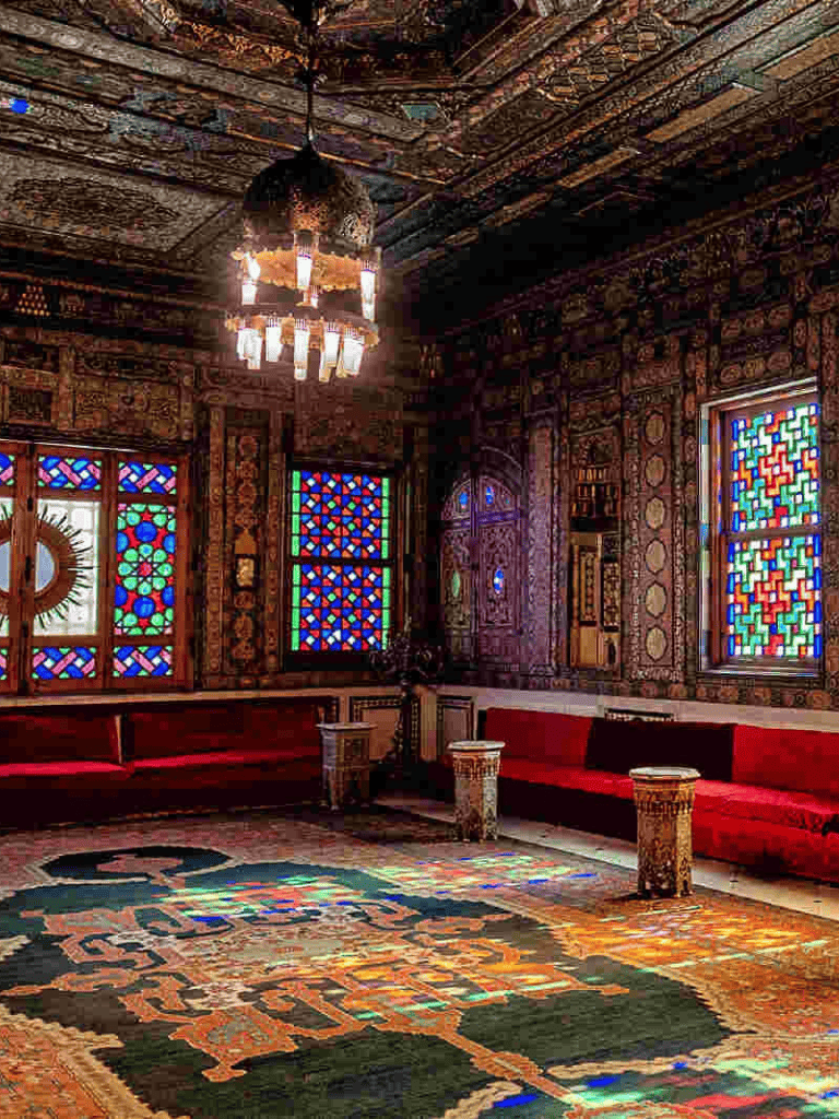 Intricate Moroccan-style interior with stained glass windows and ornate wooden details.