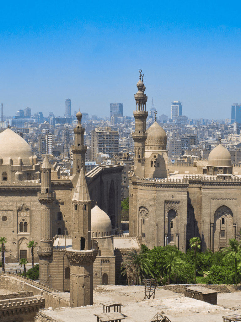 Ancient Egyptian mosque with minarets and city skyline in Cairo, Egypt.