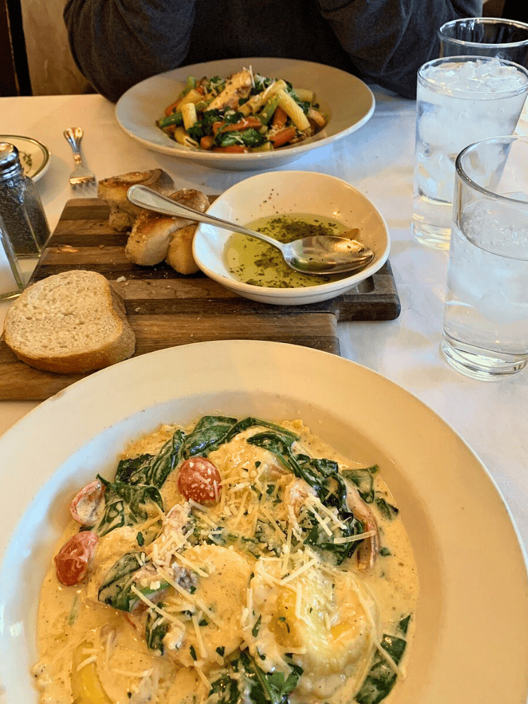 Fresh Italian pasta with spinach, cherry tomatoes, and Parmesan cheese at QuestForDirections restaurant.