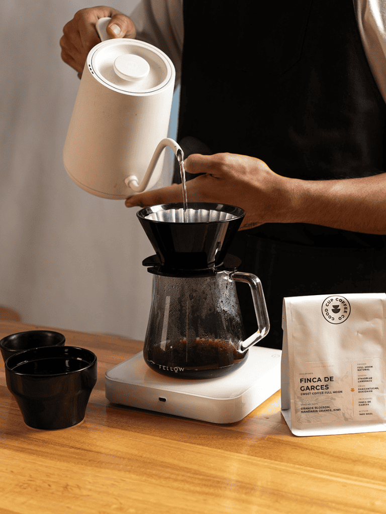 Warm coffee being brewed with a pour-over coffee maker, ideal for coffee enthusiasts and baristas.