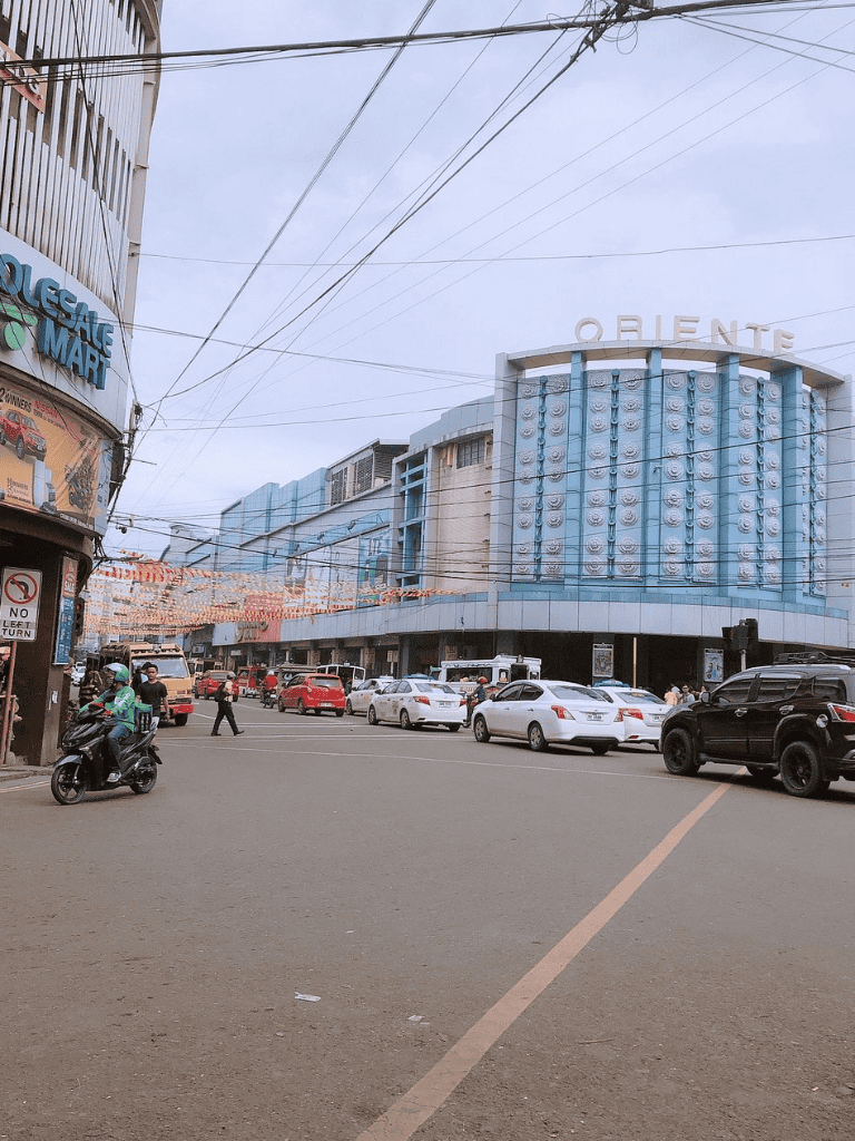 QuestForDirections urban shopping street with modern boutiques and busy traffic, vibrant city scene in the Philippines.