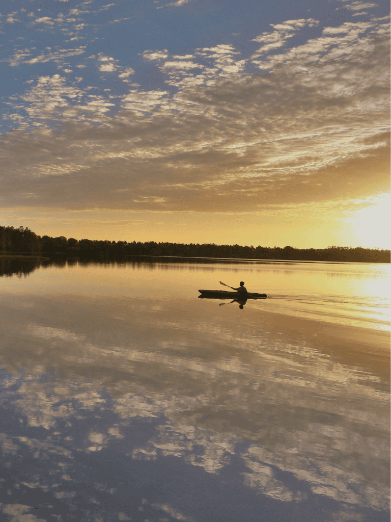 Peaceful kayak on serene lake during sunset, perfect for outdoor adventures and nature exploration.