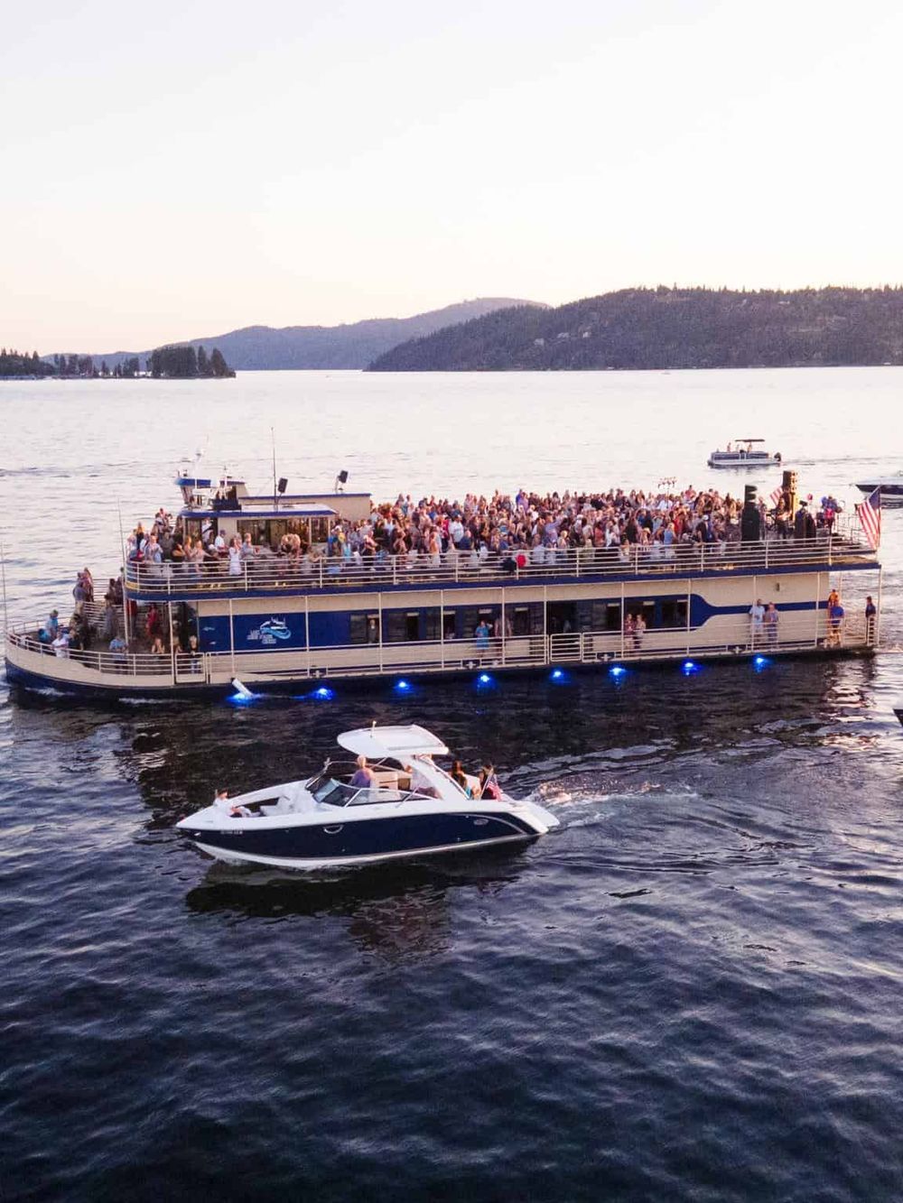 Boat cruise with large crowd on scenic lake or river, popular for sightseeing, tours, and special events.