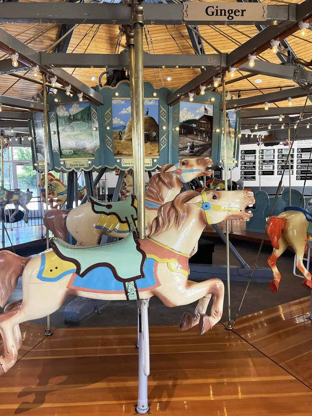 Colorful vintage carousel horses on an indoor amusement ride at QuestForDirections.