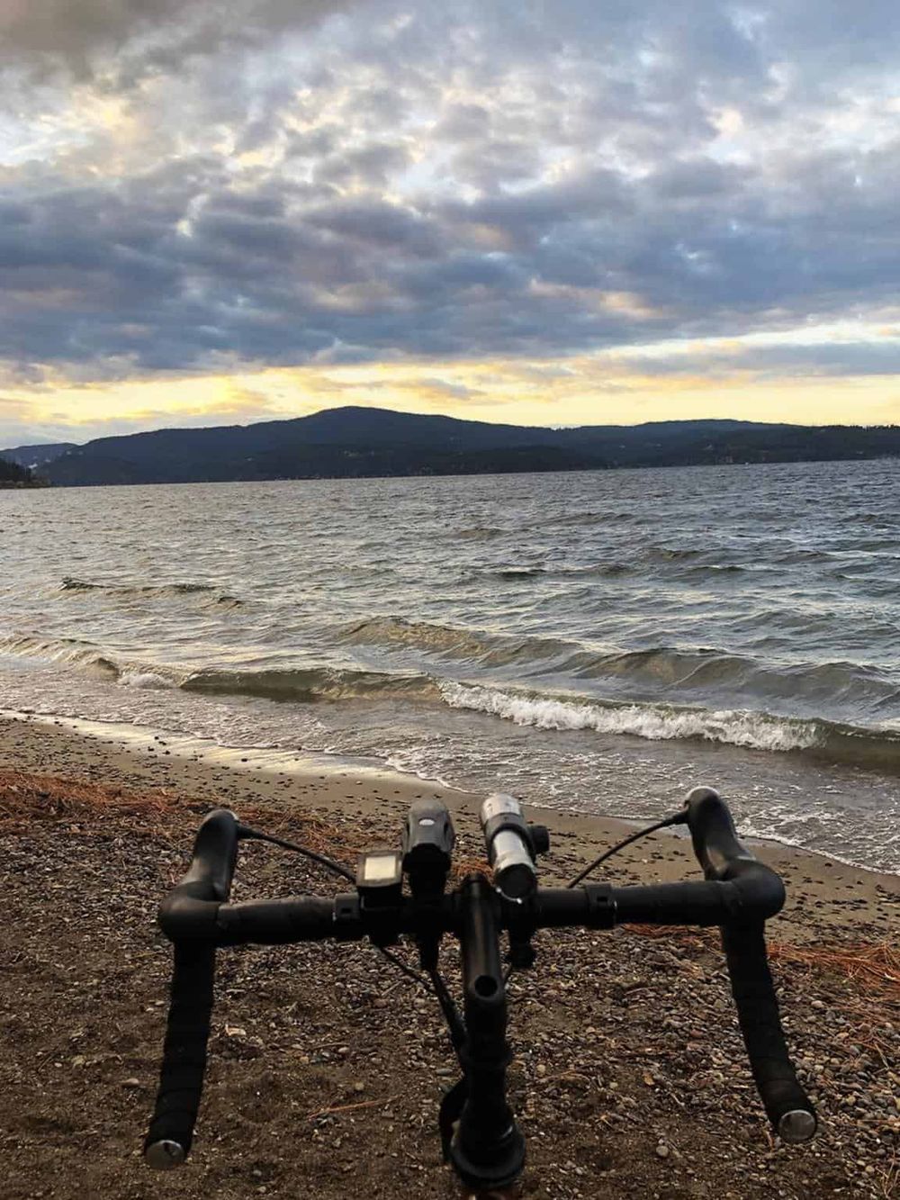 Scenic view of a bicycle at the water's edge during sunset, representing outdoor adventure and exploration.