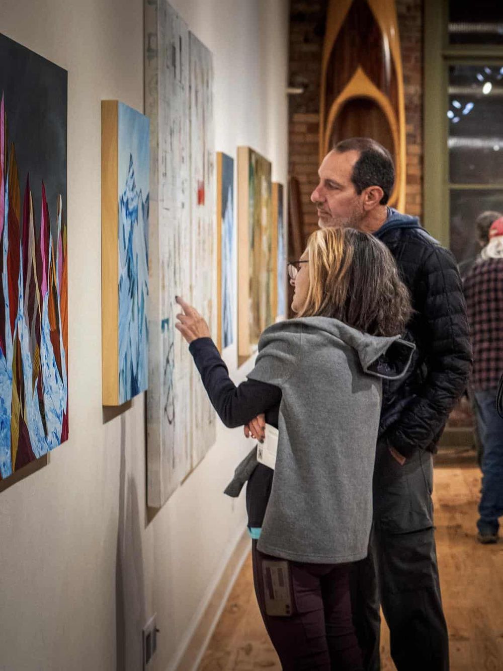 Colorful art gallery with visitors appreciating modern paintings.