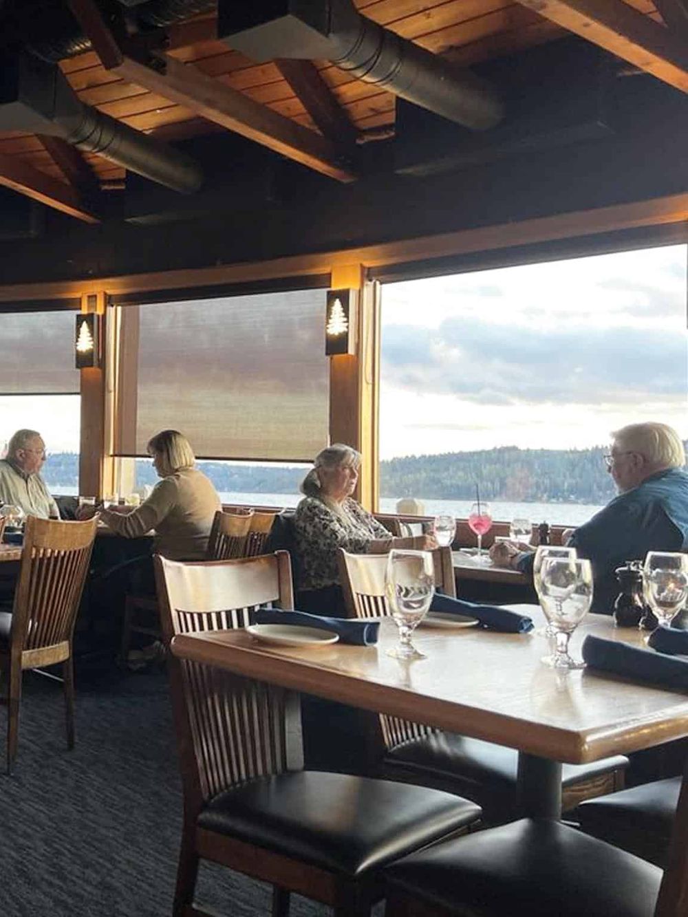 Seafood restaurant overlooking a lake with diners enjoying meals and scenic views.
