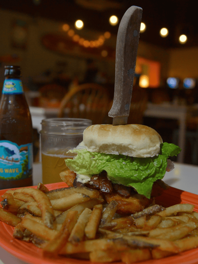 Crispy fries with a cheeseburger and fresh lettuce on a plate at a casual restaurant.