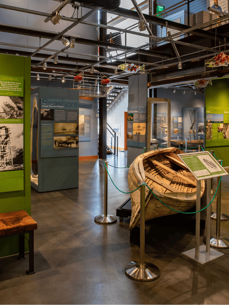 Wooden boat exhibit in a maritime museum with historical displays and information panels.