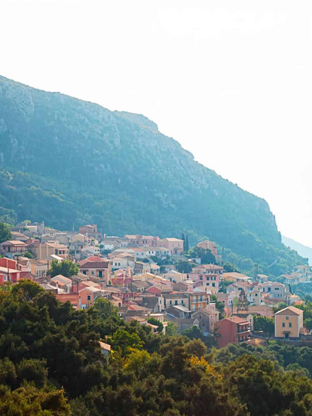 Colorful hillside town with mountain backdrop, representing scenic travel destinations.