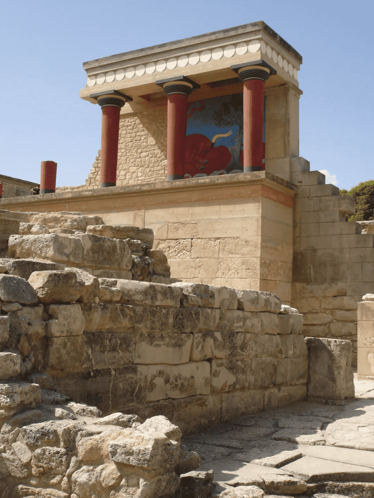 Ancient Minoan palace ruins at Knossos, Greece, with colorful fresco and stone architecture.