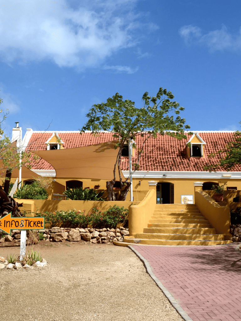 Colorful yellow building with red-tile roof and outdoor stairs at Quest for Directions.