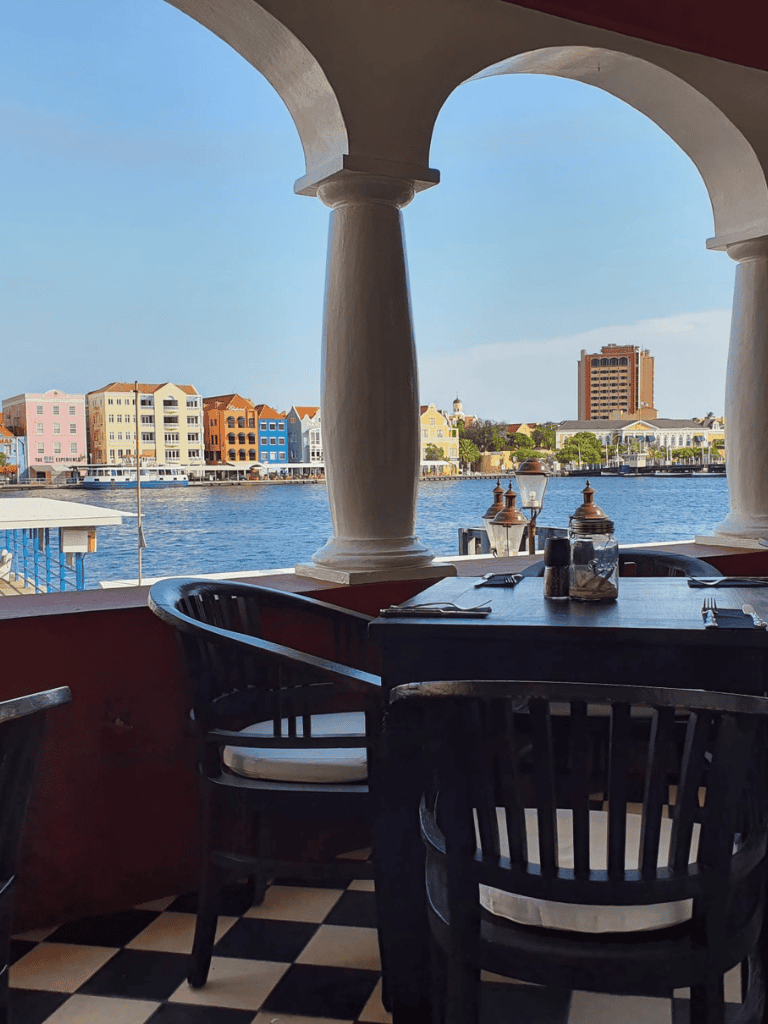 Aqua harbor view with colorful waterfront buildings and outdoor dining at QuestForDirections.