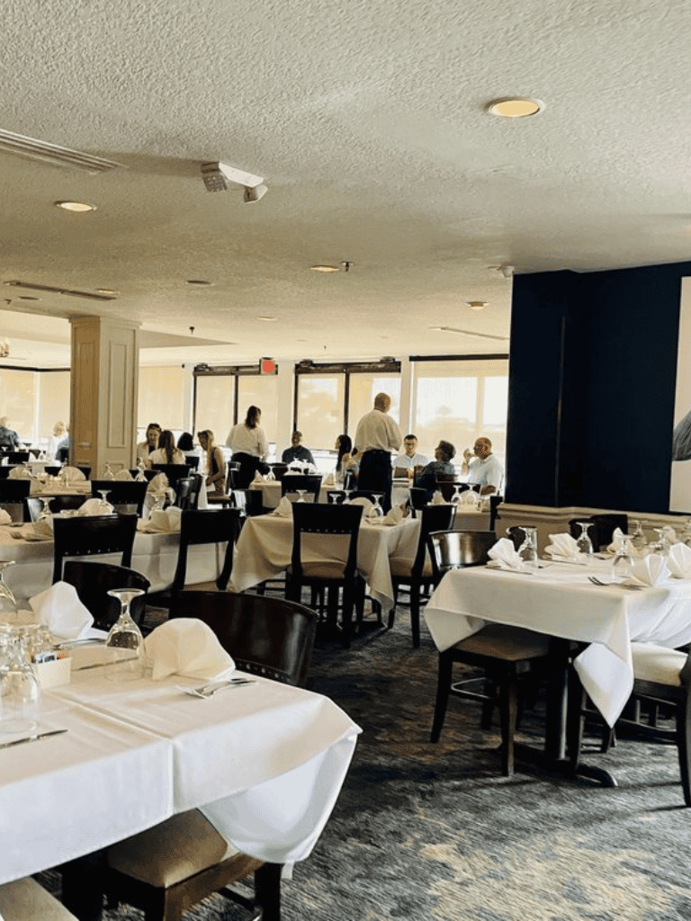 Elegant restaurant interior with neatly set tables and attentive staff for fine dining.