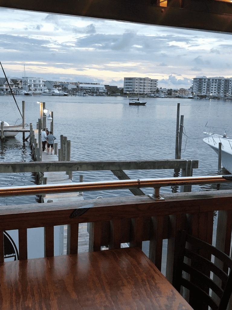 Relaxing waterfront view of boats and buildings from a balcony overlooking a marina.
