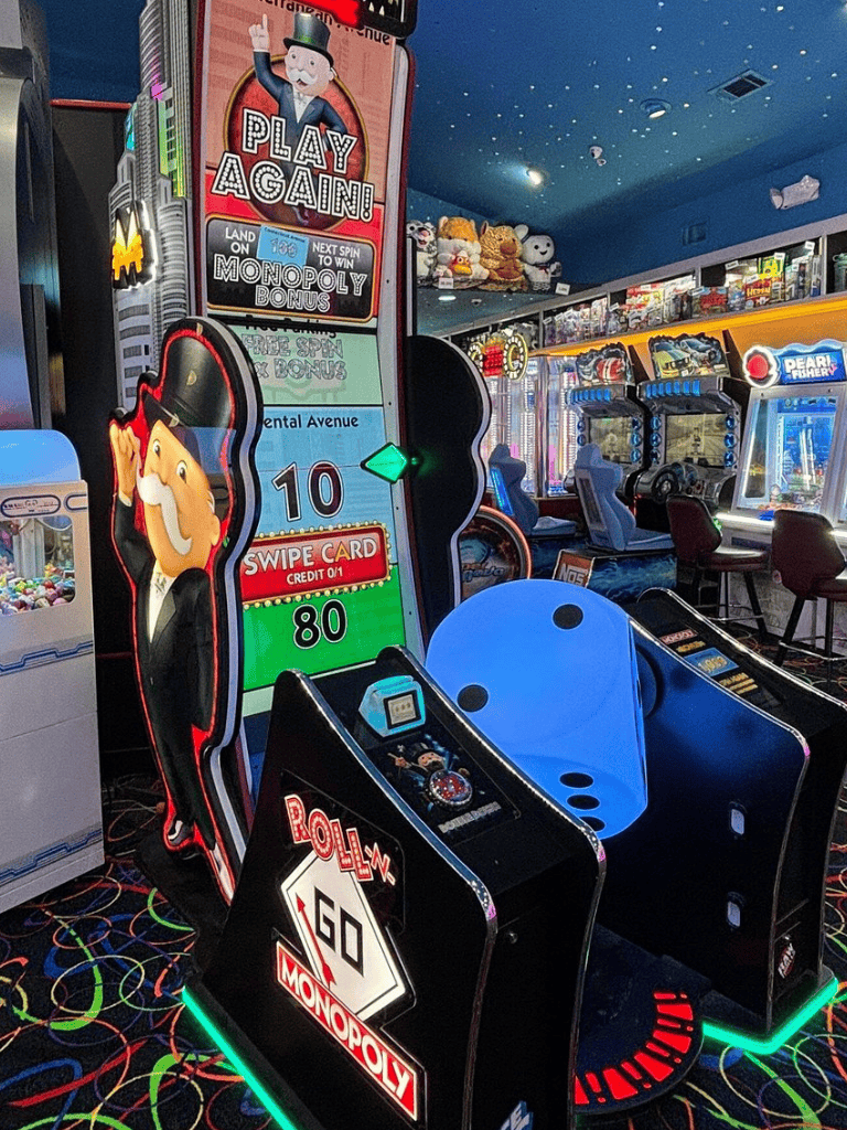 Arcade skeeball game at family entertainment center with colorful prizes and neon lights.