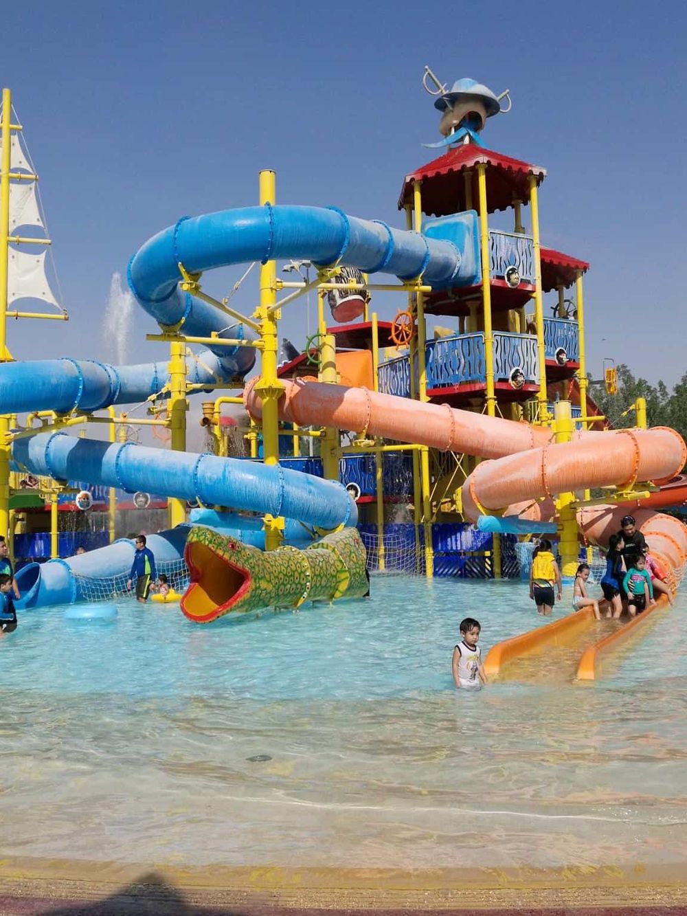 Colorful water park with slides and kids enjoying water attractions, perfect for family fun and outdoor recreation.