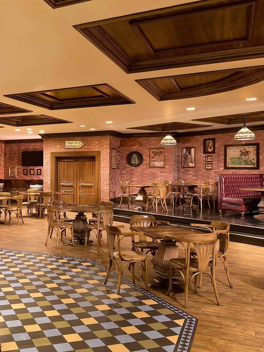 Cozy restaurant interior with wooden furniture, brick walls, framed artwork, and warm lighting; perfect for dining and socializing.