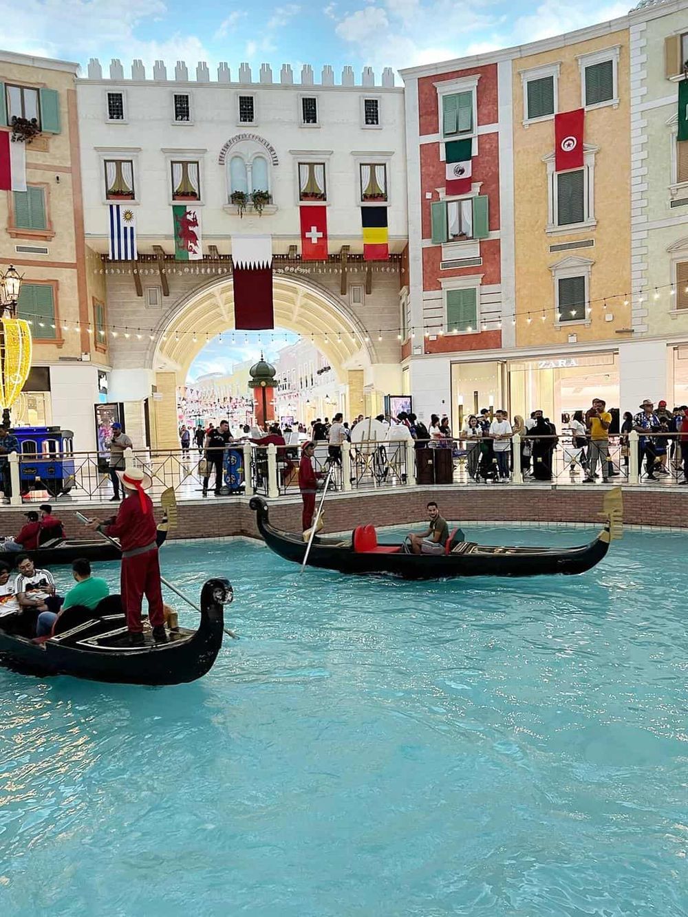 Colorful Venetian-style canal with gondola rides and shopping plaza in QuestForDirections.