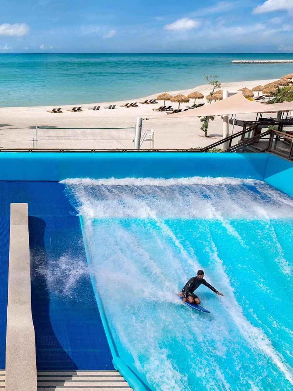 Beach resort with surf simulator and ocean view for adventure travel and aquatic activities.