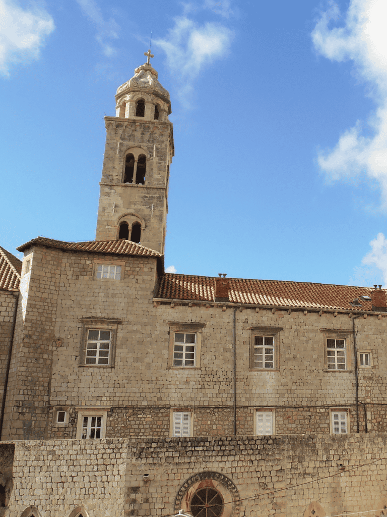 Old stone church with bell tower against blue sky, historic architecture, travel destination.